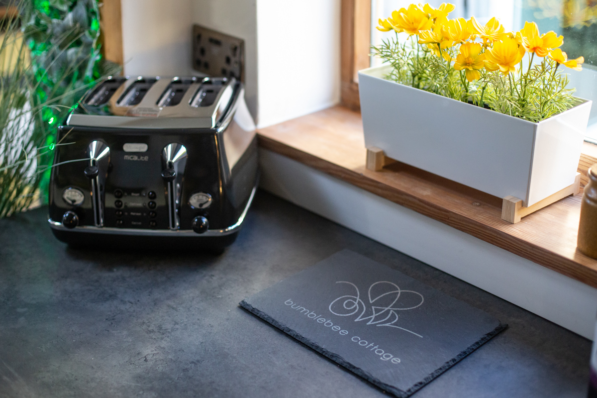 Engraved slate placemat with a property logo on a kitchen counter