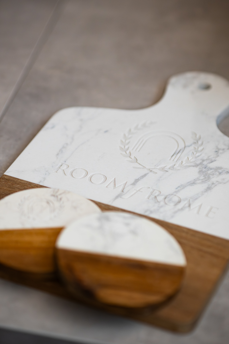 Personalised marble and wood serving board engraved with a hotel crest