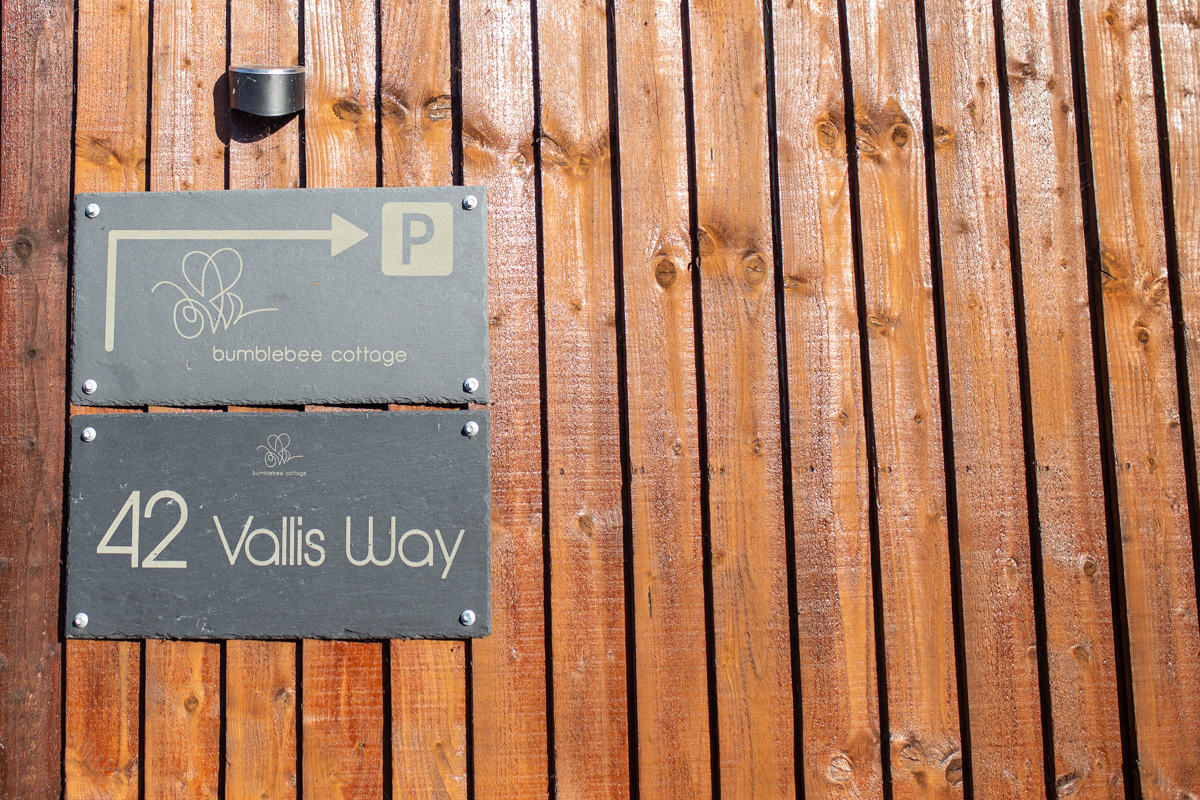 Engraved slate house number and directional parking sign for a boutique property